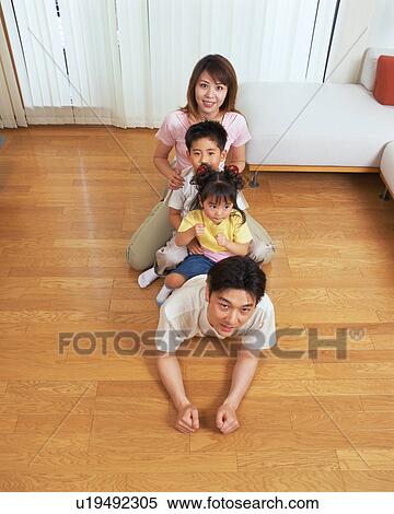 A woman along with her two children sitting on her husband's back View Large Photo Image Stock Photography - A woman along with her two children sitting on her husband's back. Fotosearch