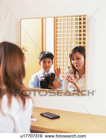 A woman applying make-up while her children look on View Large Photo Image Stock Photo - A woman applying make-up while her children look on. Fotosearch