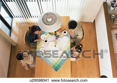 Stock Image - High angle view of a family having their breakfast together. Fotosearch