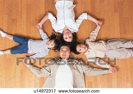 High angle view of a family lying on floor View Large Photo Image Stock Photo - High angle view of a family lying on floor. Fotosearch