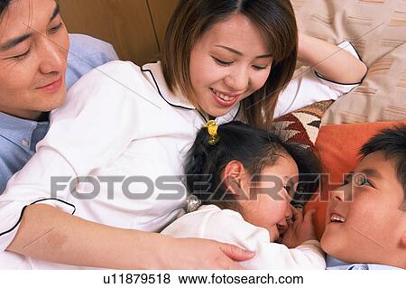 Stock Photo - Two children going to sleep beside their mother. Fotosearch