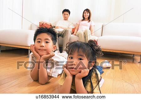 Picture - Two children lying on floor and looking at camera. Fotosearch