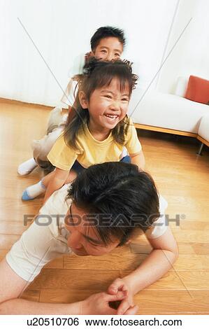 Two children sitting on their father's back View Large Photo Image Stock Photograph - Two children sitting on their father's back. Fotosearch