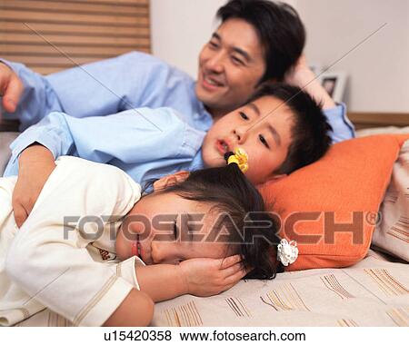 Two children sleeping along wit their father View Large Photo Image Stock Photo - Two children sleeping along wit their father. Fotosearch