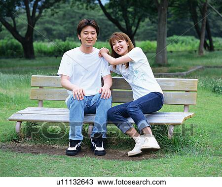 中間の 大人の カップル モデル 上に A ベンチ 中に A 公園 ストックイメージ U Fotosearch