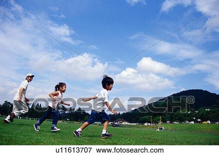 Stock Photo - A boy and a girl running in a park. Fotosearch