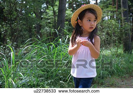 Stock Image - A girl standing in countryside. Fotosearch