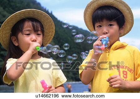 Stock Photograph - Children playing with bubbles. Fotosearch