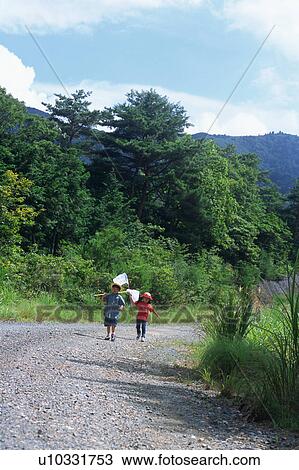 Stock Image - Children walking with butterfly net. Fotosearch