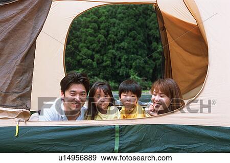 Stock Photo - Family lying on front in a tent. Fotosearch