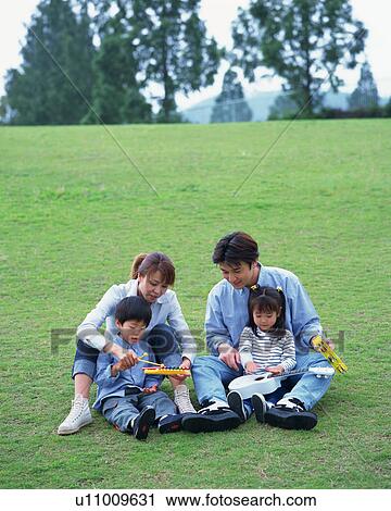 Stock Image - Family playing in a park. Fotosearch