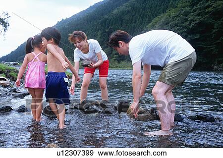 Family playing in a river View Large Photo Image Stock Photo - Family playing in a river. Fotosearch