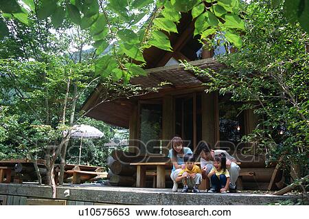 Family sitting outside of log cabin View Large Photo Image Stock Image - Family sitting outside of log cabin. Fotosearch