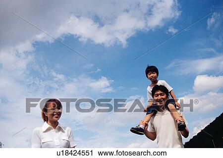 Stock Image - Father carrying his son on shoulders. Fotosearch