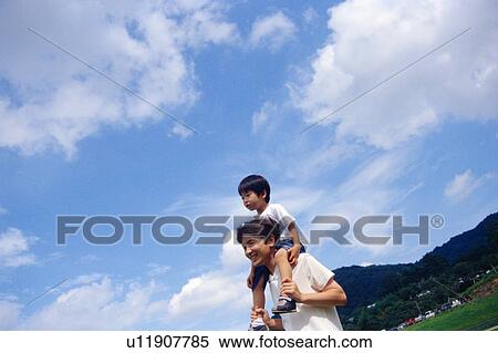 Stock Photography - Father carrying his son on shoulders. Fotosearch