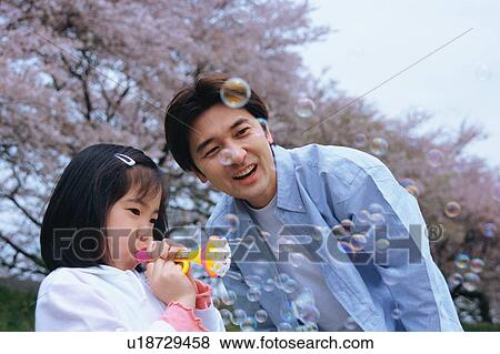 Stock Photo - Girl playing with bubble wand. Fotosearch