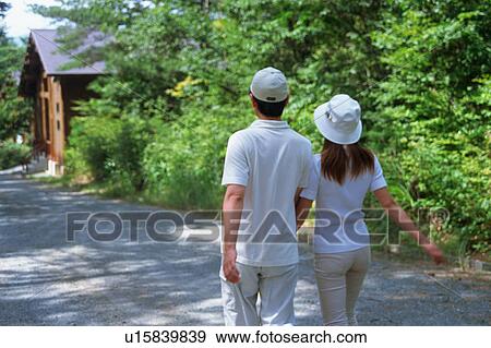 Stock Photo - Mid Adult Couple walking in countryside. Fotosearch