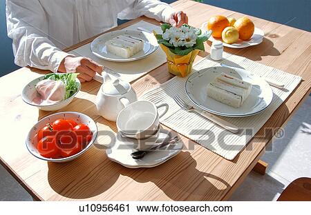 Stock Image - A man sitting at a table for breakfast. Fotosearch