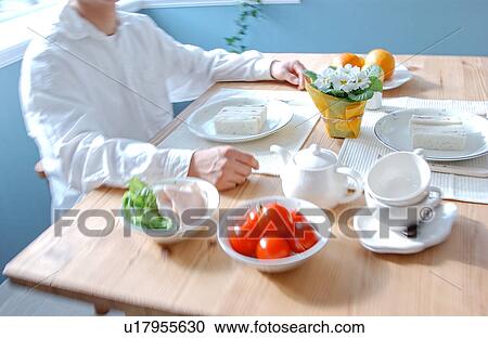 A man sitting at a table for breakfast View Large Photo Image Stock Image - A man sitting at a table for breakfast. Fotosearch