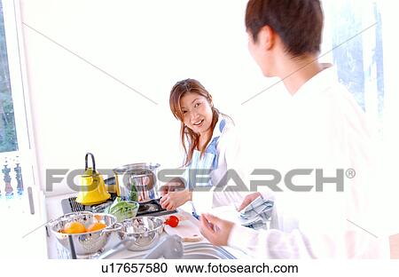 A young couple cooking in a kitchen View Large Photo Image Stock Image - A young couple cooking in a kitchen. Fotosearch