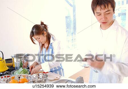 A young couple cooking in a kitchen, blurred motion View Large Photo Image Stock Photo - A young couple cooking in a kitchen, blurred motion. Fotosearch