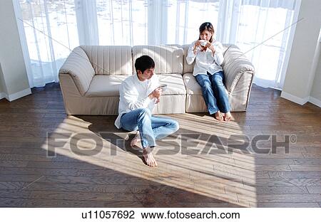 A young couple drinking a cup of coffee View Large Photo Image Stock Image - A young couple drinking a cup of coffee. Fotosearch