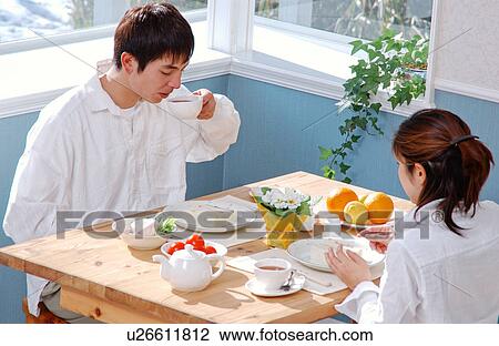 A young couple eating breakfast View Large Photo Image Stock Image - A young couple eating breakfast. Fotosearch