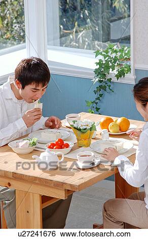 A young couple eating breakfast View Large Photo Image Stock Photograph - A young couple eating breakfast. Fotosearch