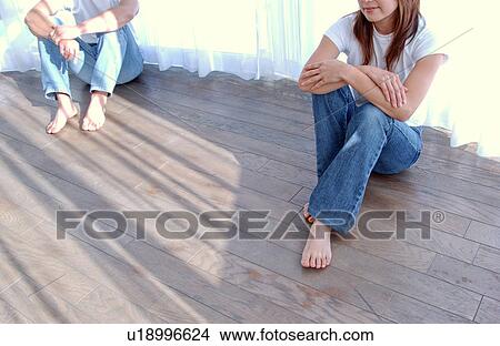 Picture - A young couple sitting on floor. Fotosearch