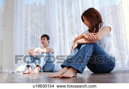 Picture - A young couple sitting on floor. Fotosearch