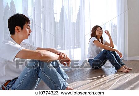 Stock Image - A young couple sitting on floor. Fotosearch