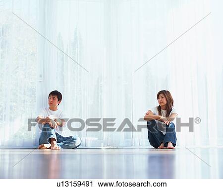 Stock Image - A young couple sitting on floor. Fotosearch