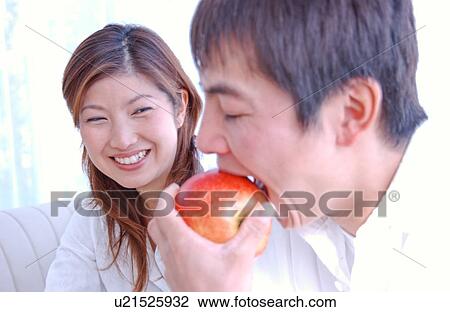 Stock Image - A young man eating an apple. Fotosearch