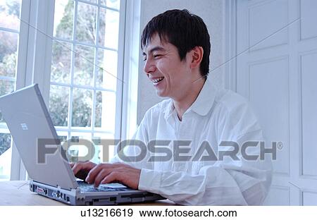 A young man using computer View Large Photo Image Stock Photo - A young man using computer. Fotosearch