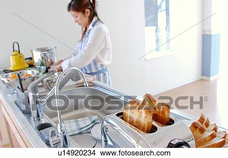A young woman cooking in a kitchen View Large Photo Image Picture - A young woman cooking in a kitchen. Fotosearch