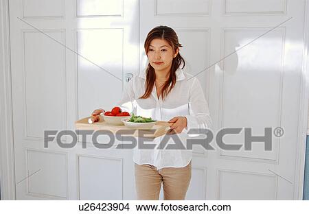 Picture - A young woman holding a tray. Fotosearch