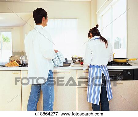 Stock Photo - Young couple cooking in a kitchen. Fotosearch