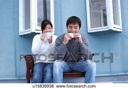 Stock Photo - Young couple eating sandwiches. Fotosearch