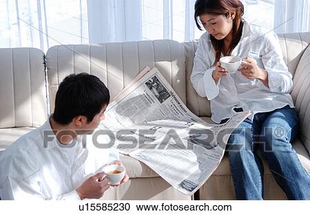 Young couple reading newspaper View Large Photo Image Stock Image - Young couple reading newspaper. Fotosearch