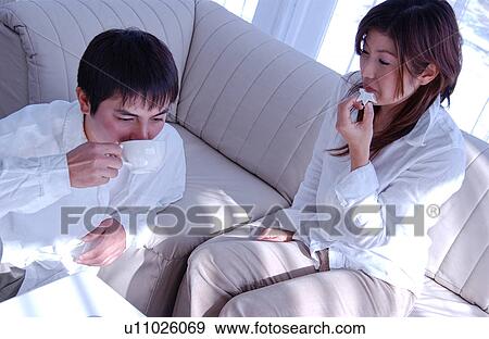 Stock Photo - Young couple relaxing in living room. Fotosearch