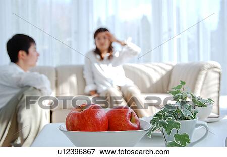 Young couple relaxing in living room View Large Photo Image Stock Photo - Young couple relaxing in living room. Fotosearch