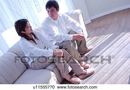 Young couple talking in a living room View Large Photo Image Stock Image - Young couple talking in a living room. Fotosearch