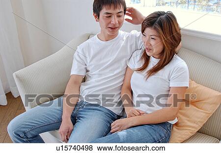Young couple talking in a living room View Large Photo Image Stock Photo - Young couple talking in a living room. Fotosearch