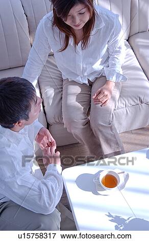 Young couple talking in a living room View Large Photo Image Stock Photo - Young couple talking in a living room. Fotosearch