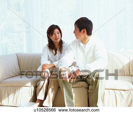 Stock Photograph - Young couple talking in a living room. Fotosearch