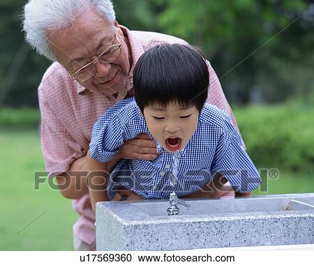 A boy drinking tap water in a park View Large Photo Image Stock Image - A boy drinking tap water in a park. Fotosearch