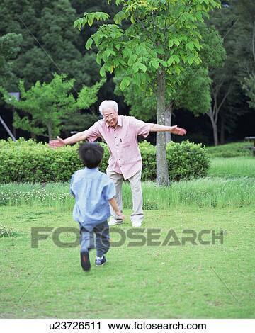 Stock Image - A boy running toward a grand father. Fotosearch