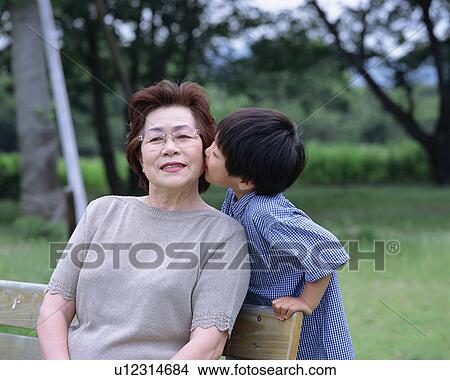 Picture - A boy whispering to grand mother. Fotosearch