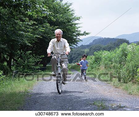 Stock Image - A grand father riding a bicycle. Fotosearch