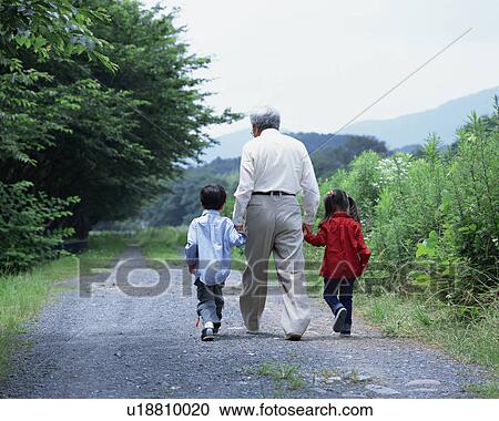 Stock Image - A grand father walking with grand children. Fotosearch